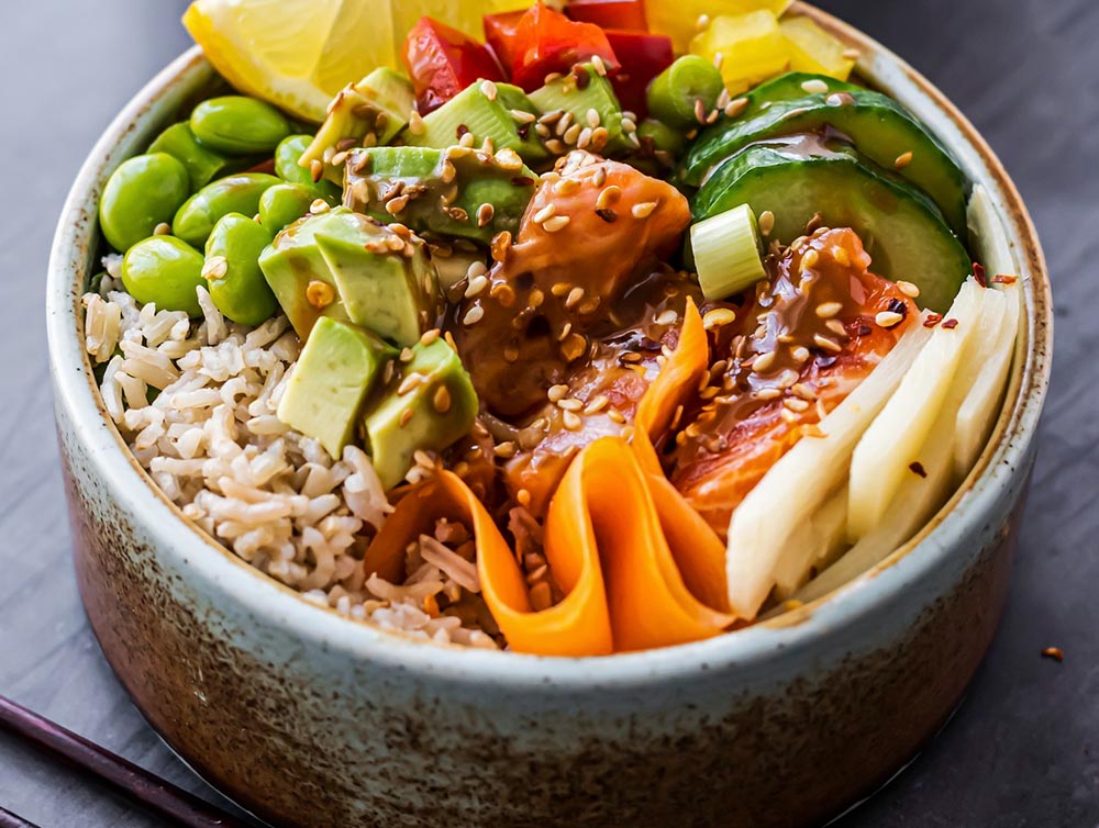 Le poké bowl california : un hommage au california roll. Base de riz, mélange de chair de crabe ou surimi, avocat, concombre, graines de sésame.