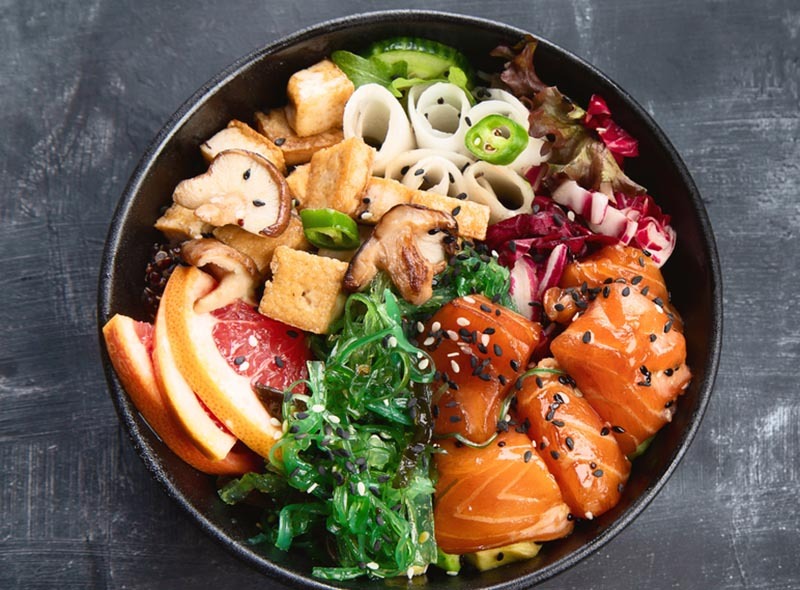 le saumon aigre-doux passion : base riz noir (vénéré), saumon mariné dans une sauce à base de fruit de la passion, miel et shoyu. Garnitures : noix de cajou, pamplemousse rose et sésame noir. (Variante exotique et originale)